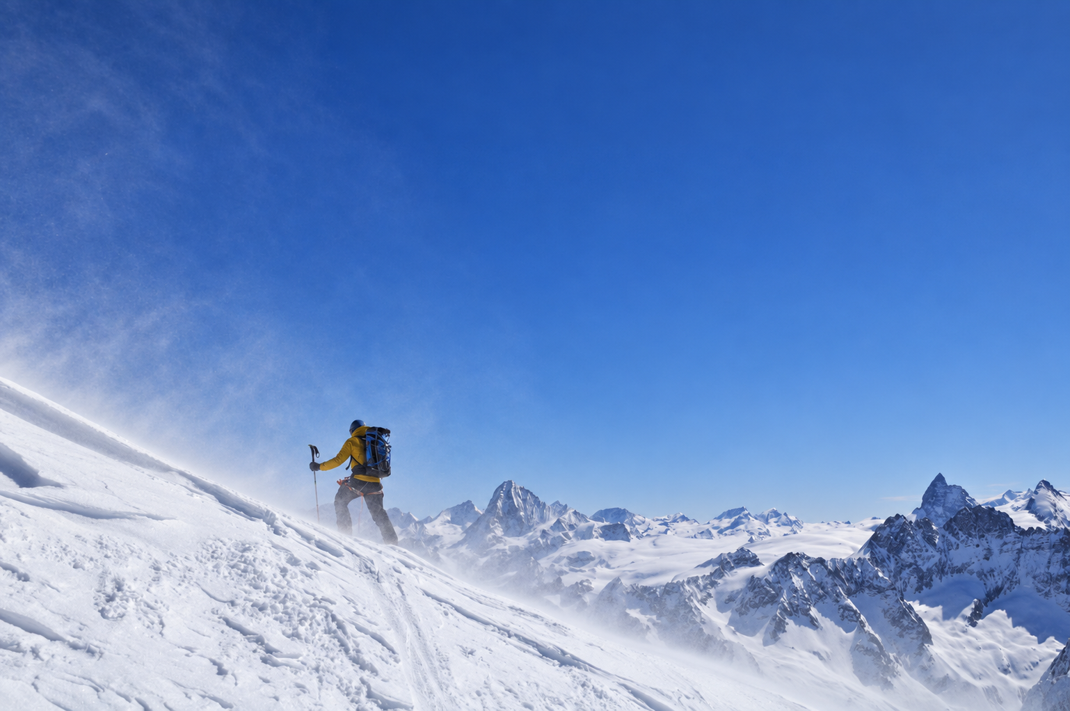 Ski mountaineer in windblown snow above the Ötztal mountain panorama