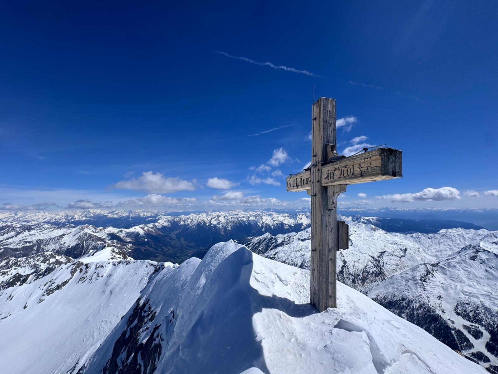 Summit cross above snowy peaks at Liebener Spitze